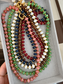 Collana con rondelle in malachite e perline in acciaio dorato