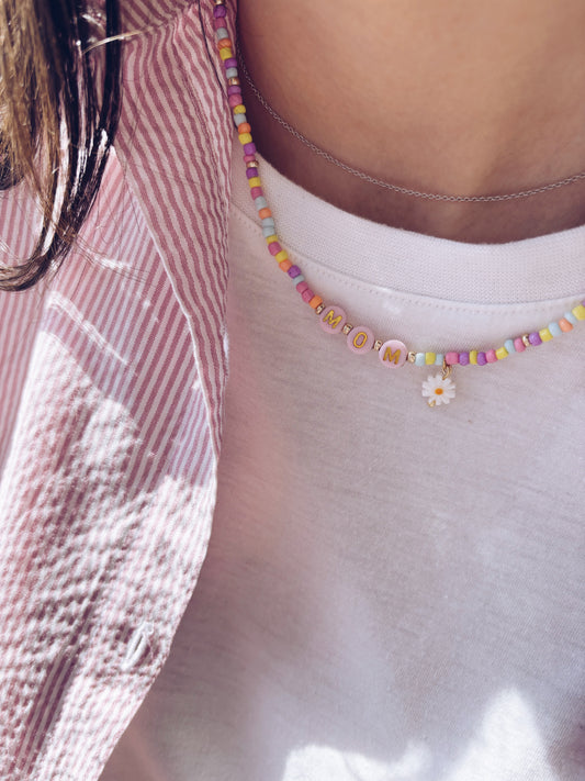 Collana con perline in vetro, letterine e margherita pendente