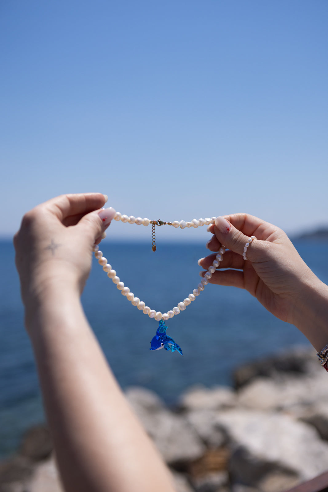 Collana con perle di fiume e delfino in vetro