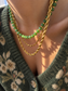 Collana con rondelle in malachite e perline in acciaio dorato