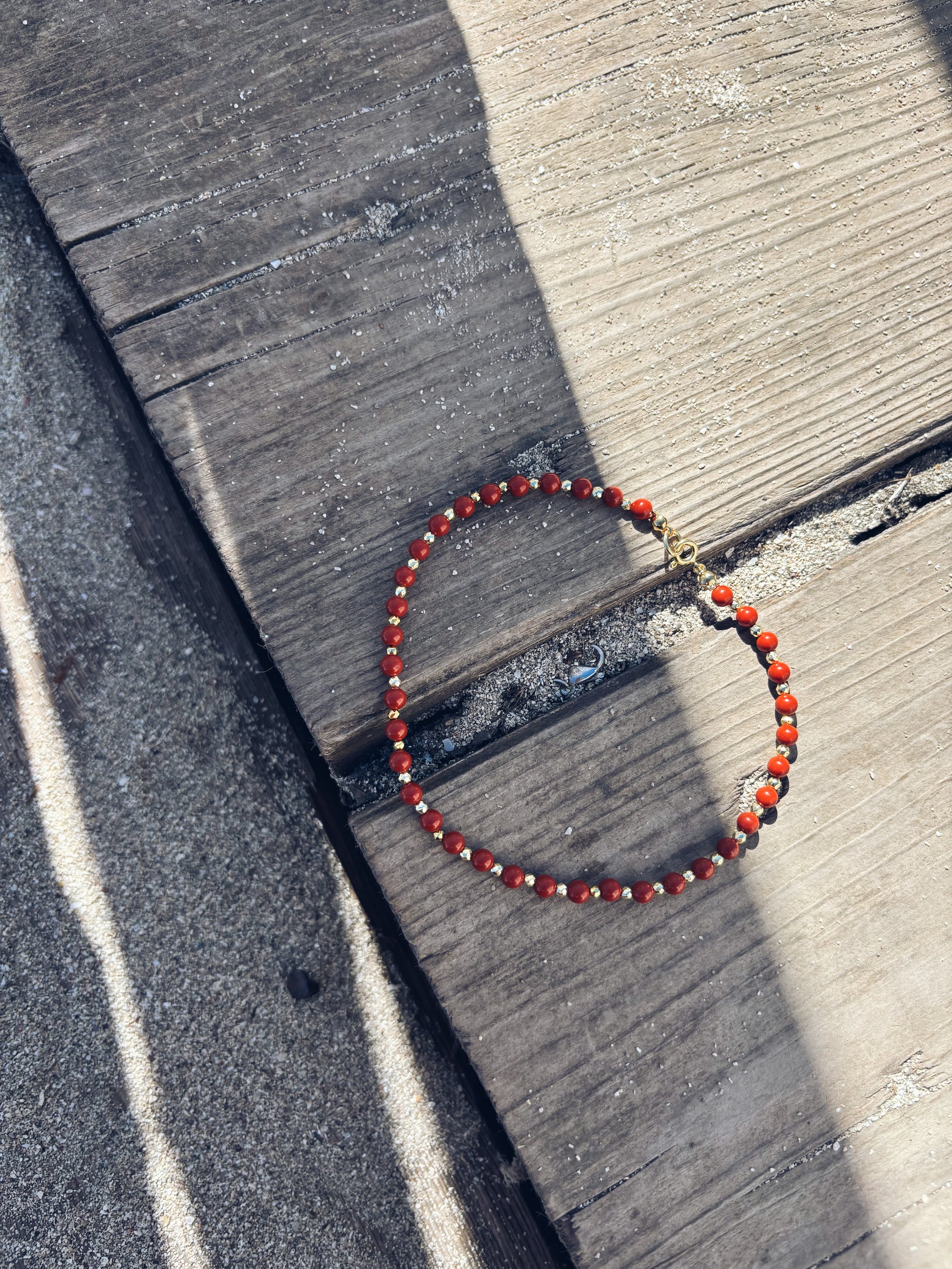 Cavigliera in pasta di corallo rosso e hematite oro - Dettagli di Moda
